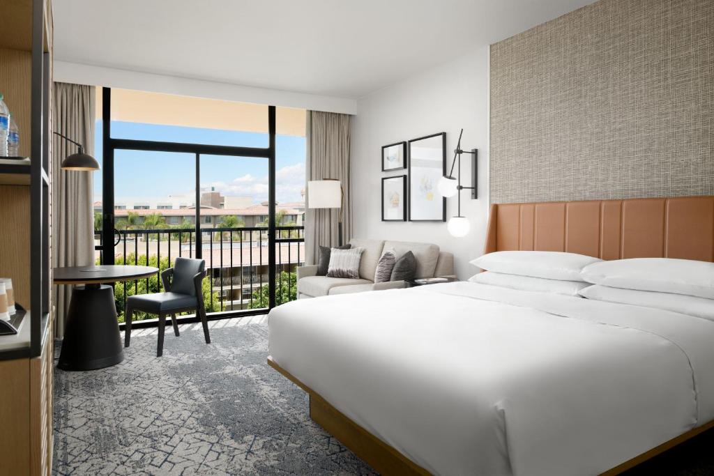 a hotel room with a large bed and a balcony at Sheraton Park Hotel at the Anaheim Resort in Anaheim