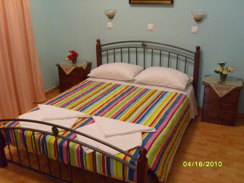 a bedroom with a large bed with colorful sheets and pillows at Elisabeth Villas in Kerveli
