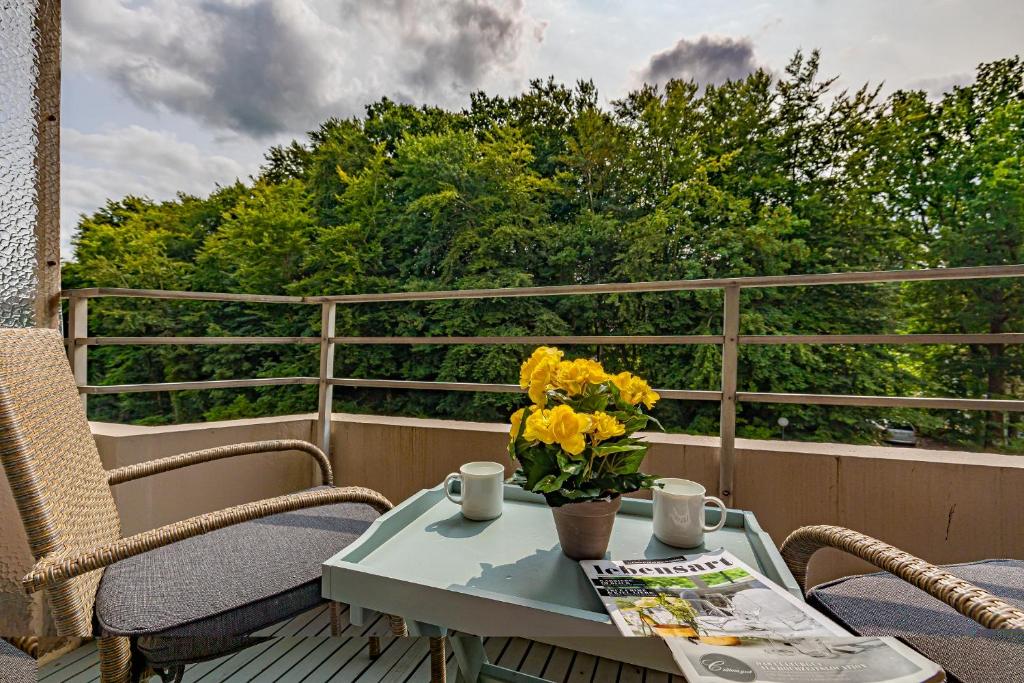 a table with a vase of yellow flowers on a balcony at fewo1846 Intermar - Gruene Insel - Studioapartment mit Balkon und Blick ins Grüne in Glücksburg
