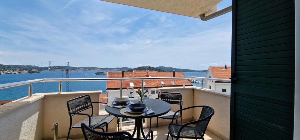 Un balcón con mesa y sillas y vista al agua. en Adriapartman, en Rogoznica