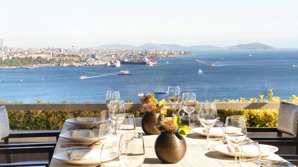 a table with glasses and a view of the ocean at CVK Park Bosphorus Hotel Istanbul in Istanbul