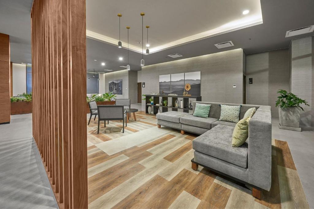a living room with a couch and a table at City Express Plus by Marriott Tijuana in Tijuana