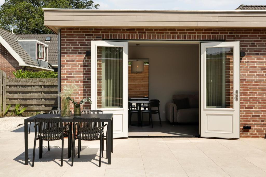un patio avec une table et des chaises et un bâtiment dans l'établissement The Ville, à Groet