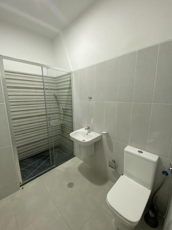 a bathroom with a toilet and a shower and a sink at Apartamento Rua Bom sossego in Sal Rei