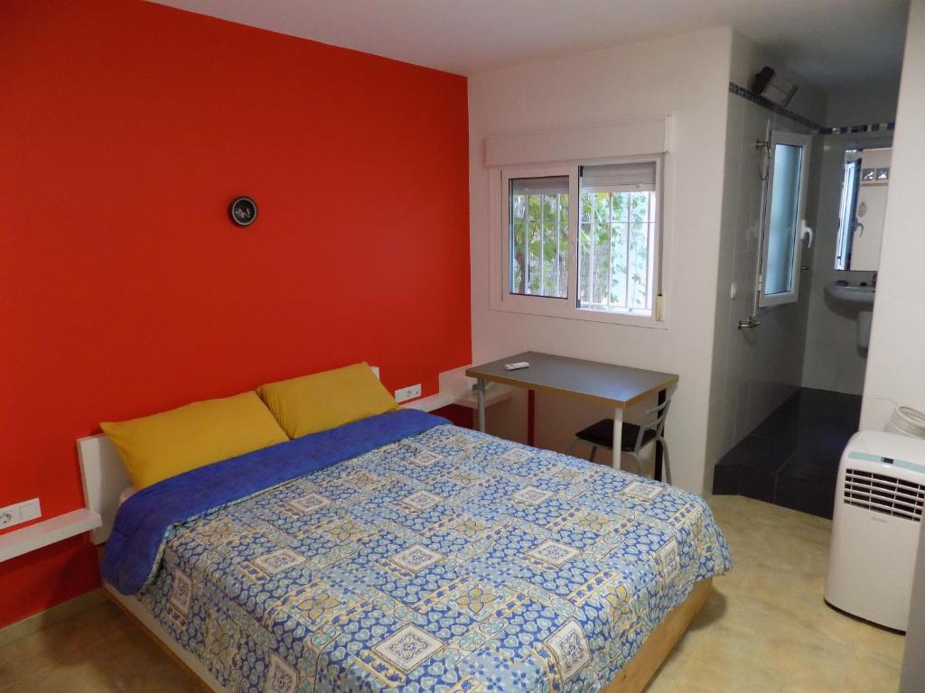 ein Schlafzimmer mit einem Bett und einer roten Wand in der Unterkunft Los Abencerrajes-Almería in Almería