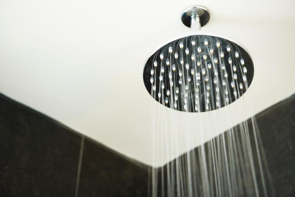a shower with a shower head in a bathroom at Hôtel Le Germain Québec in Quebec City