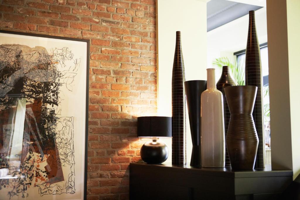 a shelf with vases and a lamp and a brick wall at Hôtel Le Germain Québec in Quebec City