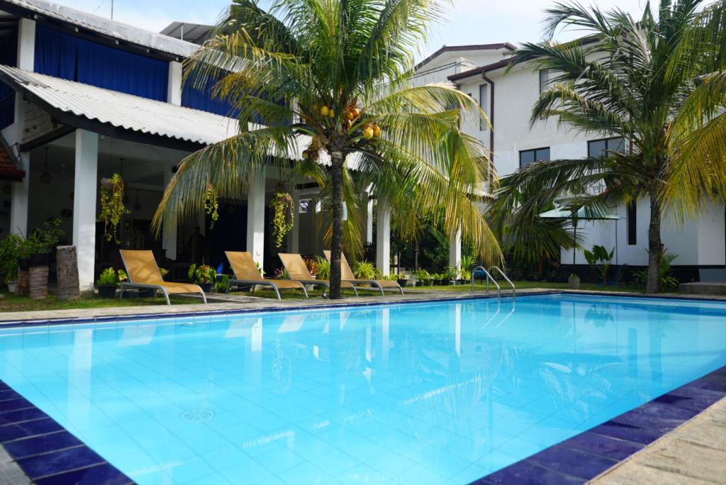 a large swimming pool in front of a hotel at Way of The Bay in Arugam Bay