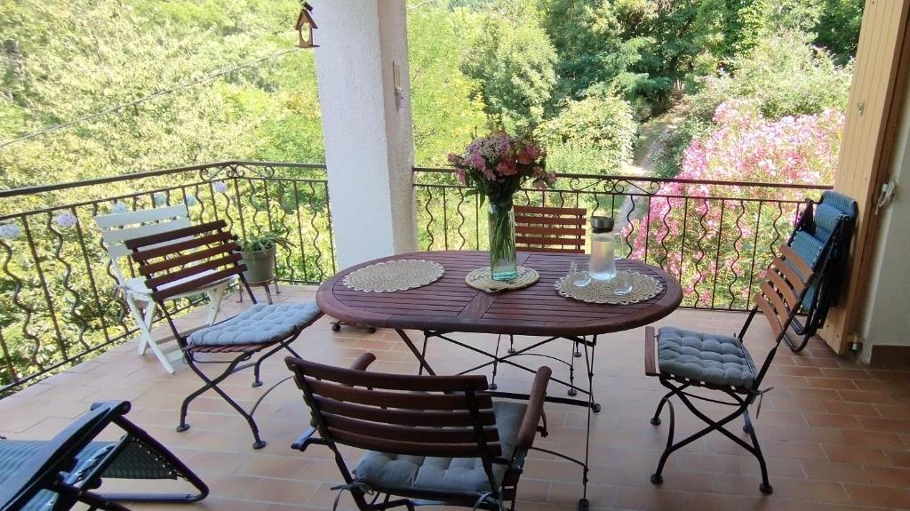 a porch with a table and chairs on a balcony at Chambres d'amis Petit déjeuner offert in Vialas