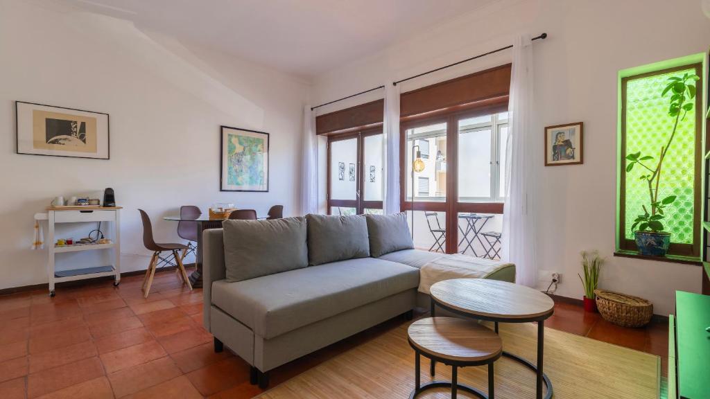 a living room with a couch and a table at Seaside Getaway With Balcony by LovelyStay in Almada
