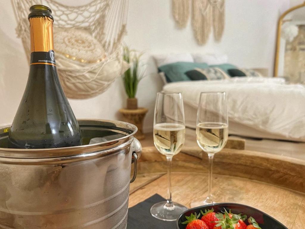 - une bouteille de vin dans un seau avec deux verres à vin dans l'établissement Bien-être au naturel, Love Room, Jacuzzi Sauna, Centre-Historique, à Avignon