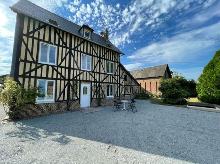 une maison avec deux vélos garés devant elle dans l'établissement Gite au cœur des pâturages, à Le Pré-dʼAuge