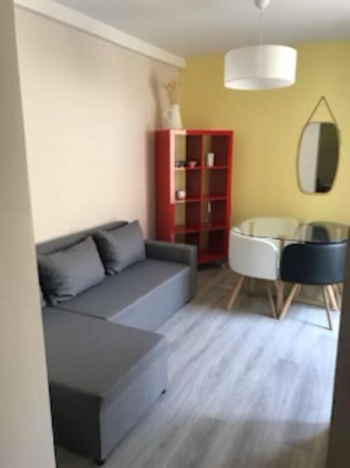 un salon avec un canapé et une table dans l'établissement Puteaux : Appartement spacieux pour 5 personnes, à Puteaux
