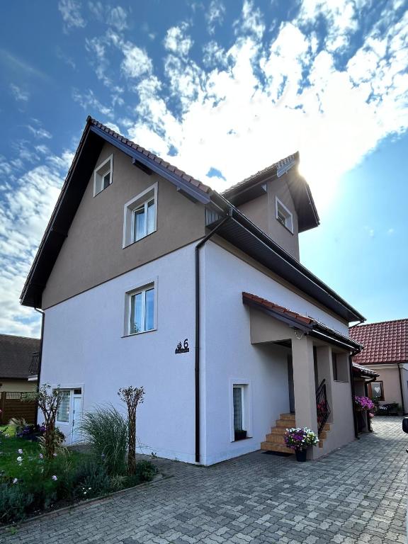 a white house with a black roof at Dom Gościnny Stokrotka in Pustkowo
