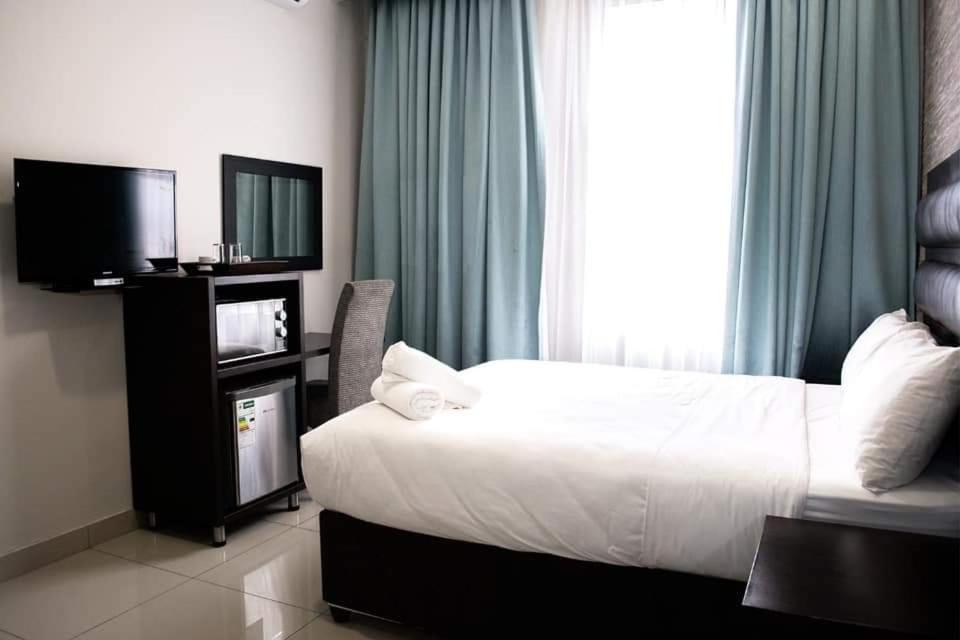 ダーバンにあるBayside Hotel 97 Russell Streetのベッドと薄型テレビがあるホテルの部屋