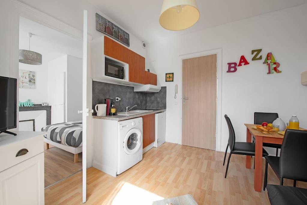 ein Wohnzimmer mit einem Bett und eine Küche mit einer Waschmaschine in der Unterkunft Aurore - T1 15 in Carcassonne