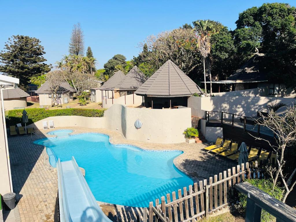 a large swimming pool with a slide in a yard at Banana Beach Club Unit A2 in Port Shepstone
