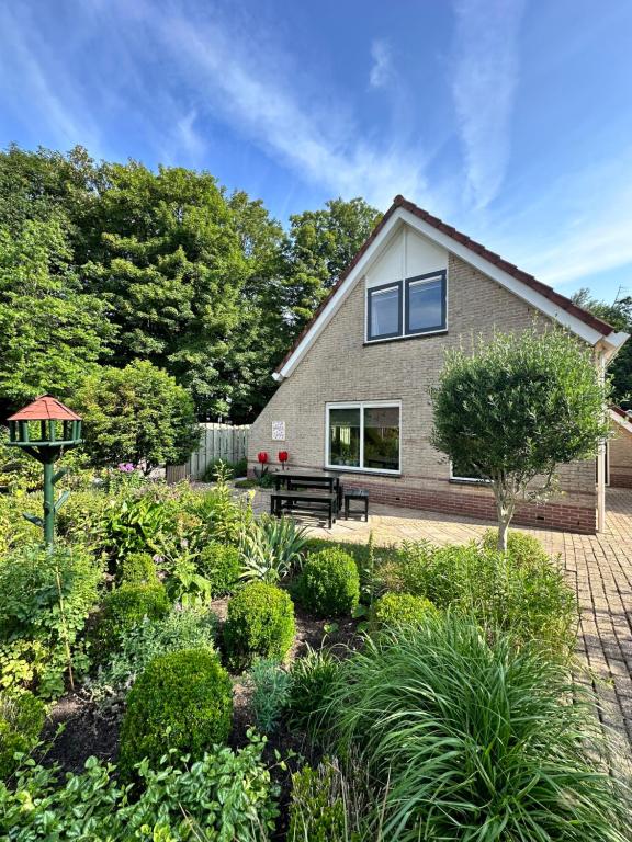 ein Garten vor einem Haus in der Unterkunft - Tulipa - Vakantiehuis nabij de bloembollenvelden, het meer en strand in Noordwijkerhout