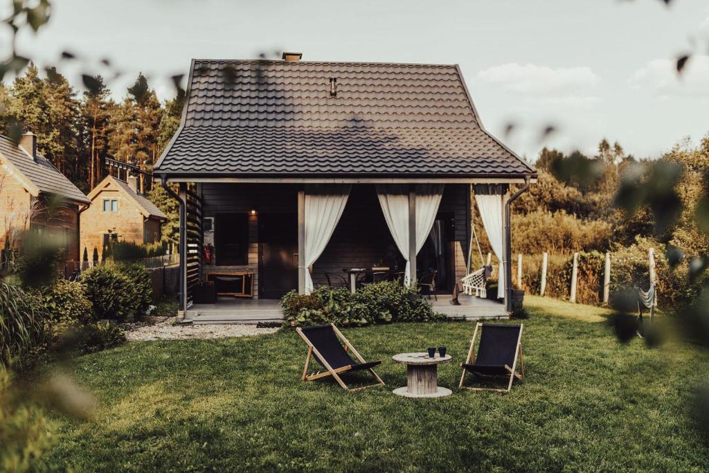 a house with two chairs and a table in the yard at Leśny Azyl Marózek in Maróz