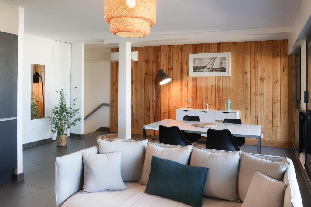 a living room with a couch and a table at Résidence Les Suites Du Ferret in Cap-Ferret