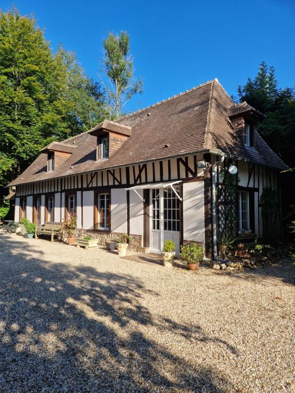 ein Haus mit einem Gamerleit auf einer Kieseinfahrt in der Unterkunft gîte du moulin de Granchain in Bernay