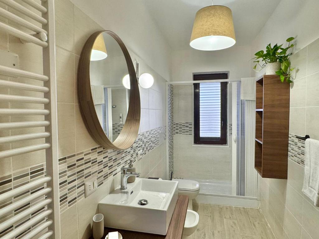 a white bathroom with a sink and a mirror at Casa Spartea Cilento coast in Marina di Camerota
