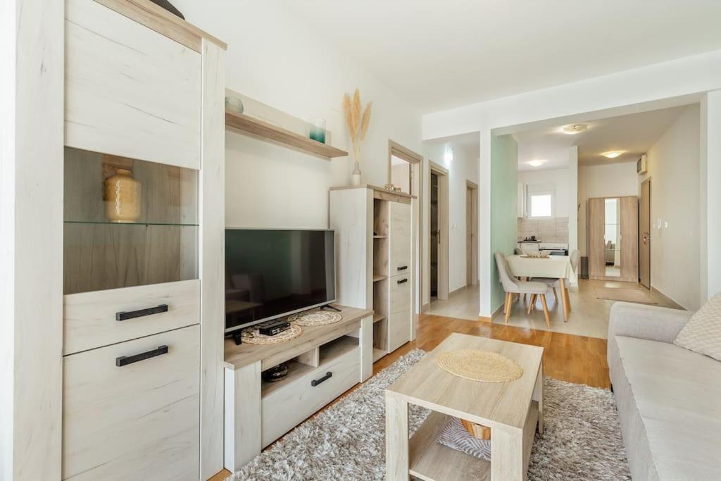 Ein weißes Wohnzimmer mit Fernseher und Sofa in der Unterkunft Luka 17 in Herceg-Novi