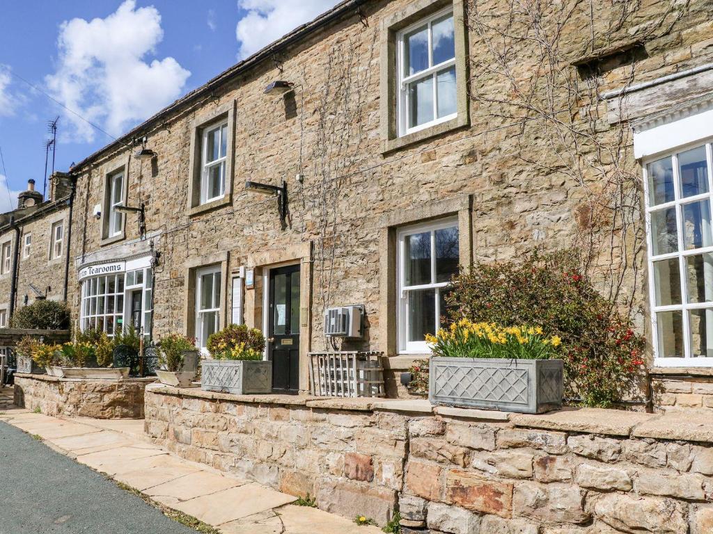 a brick building with windows and potted plants at Keartons - Buttertubs in Richmond