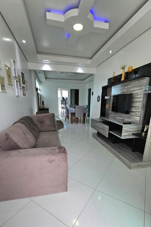 a living room with a couch and a flat screen tv at Apartamentos - Repouso do Guerreiro in Itabuna