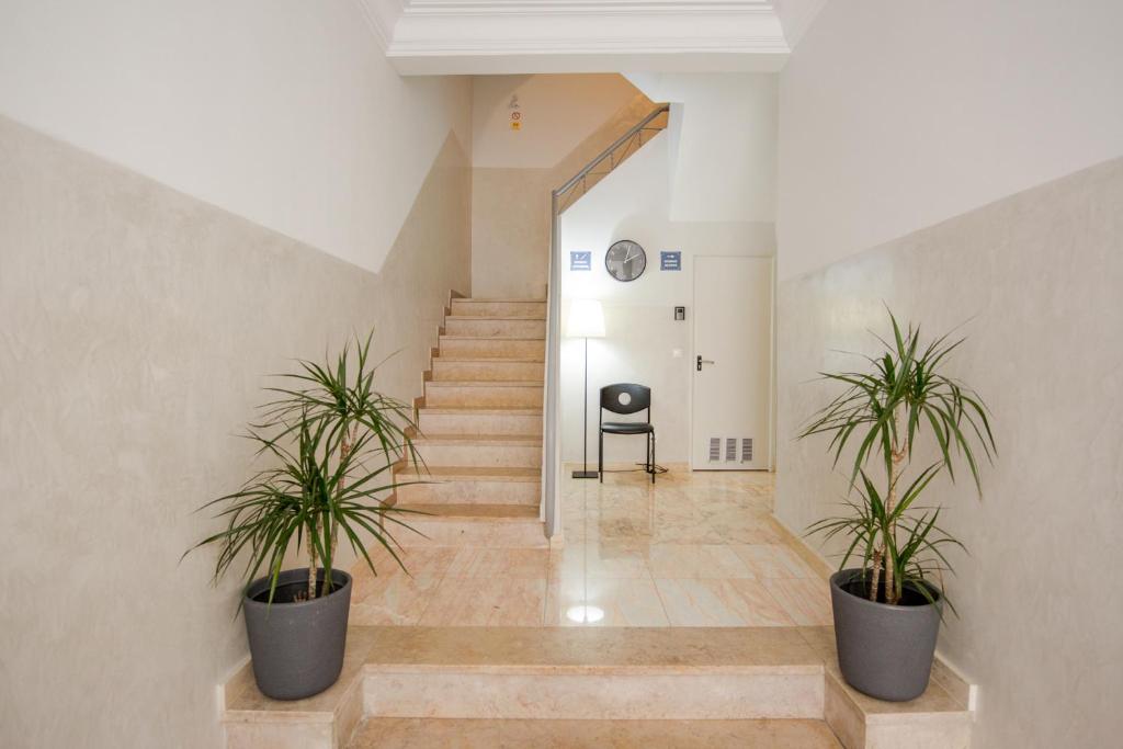 un couloir avec deux plantes en pot et un escalier dans l'établissement Rossio Studios, à Lisbonne