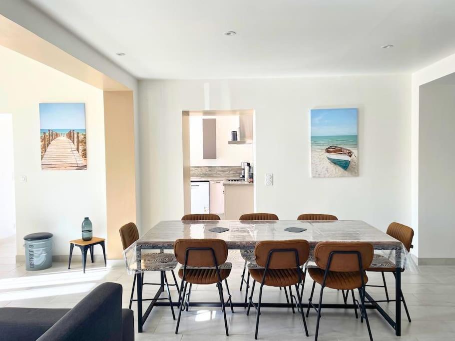 una sala da pranzo con tavolo e sedie di Le logis des Lilas a Corme-Royal