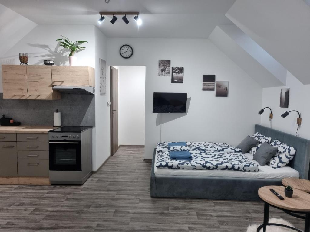 una camera da letto con un letto e una cucina con un tavolo di Apartmán Pod Hrází Chráštany a Benešov