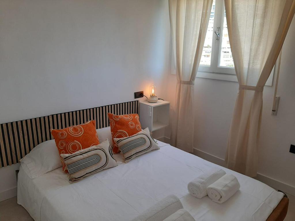 a bedroom with a white bed with pillows and a window at Paseo Marítimo Aguadulce in Aguadulce