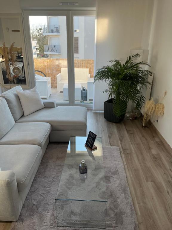 un salon avec un canapé et une table en verre dans l'établissement Stade Nautique Vaires sur Marne, à Vaires-sur-Marne