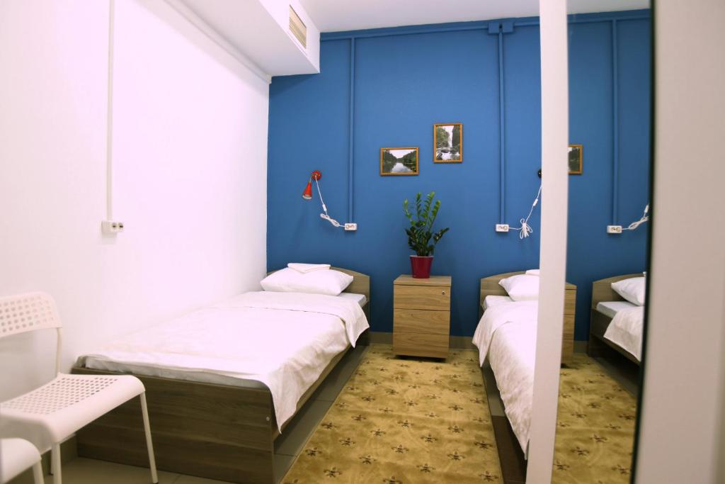 two beds in a room with blue walls at Hostel Tri Matryoshki in Irkutsk