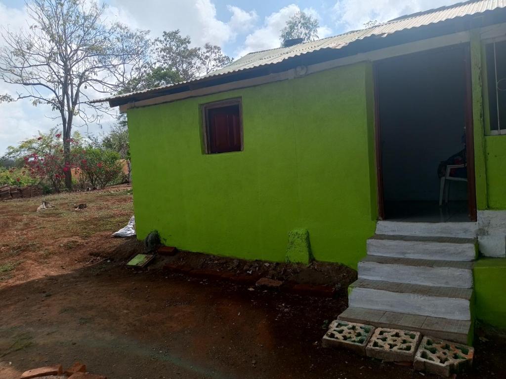 a green house with a staircase next to it at Guadalupe Herrera in Tola