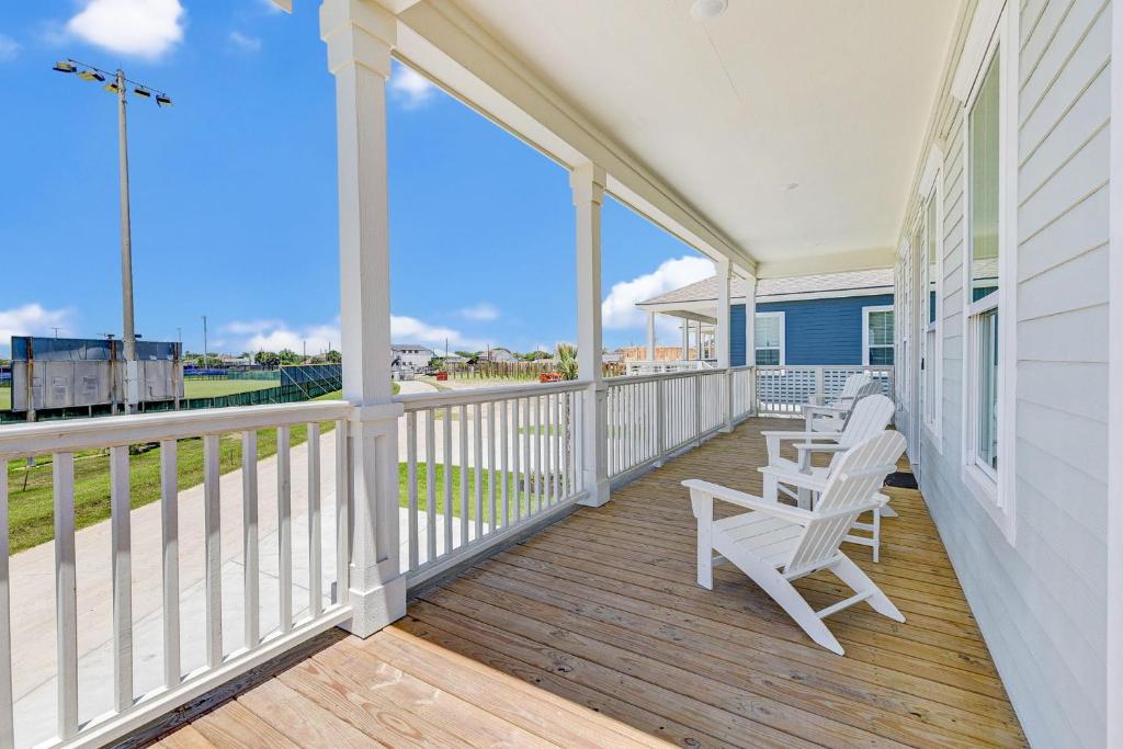 a porch with white chairs and a view of the ocean at Salt & Stone Villas in Galveston