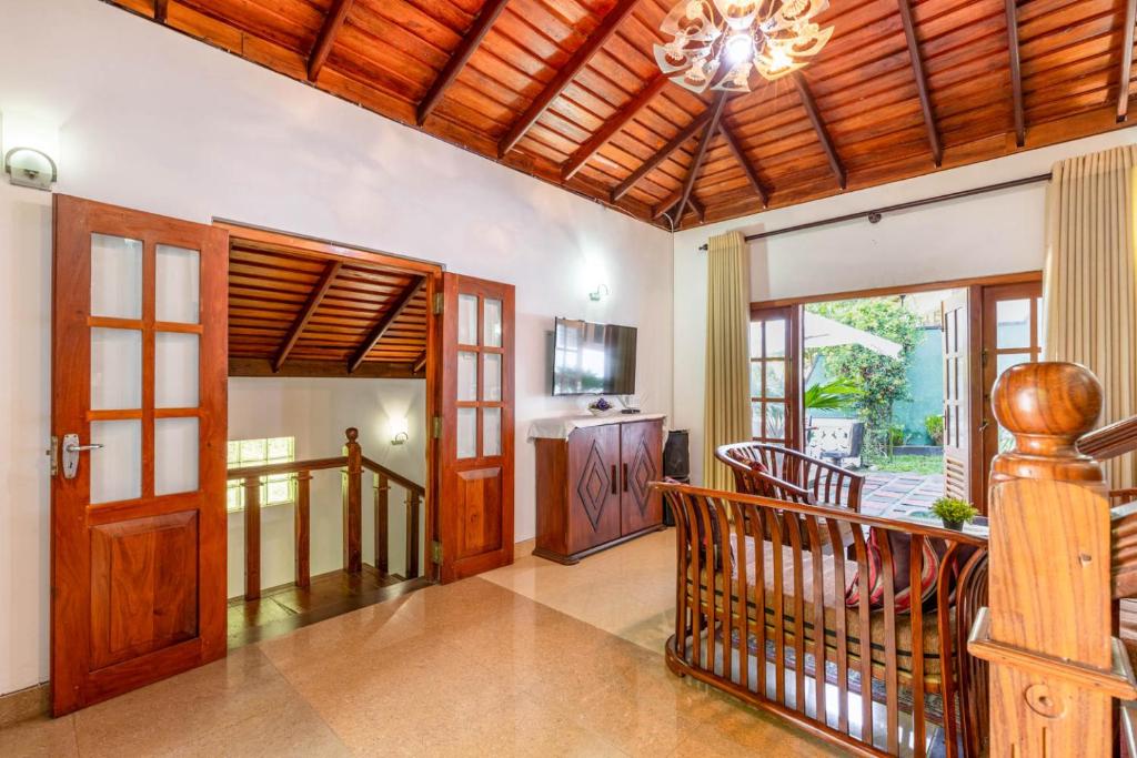 a living room with a staircase and a wooden ceiling at Villa Wedamulla in Unawatuna