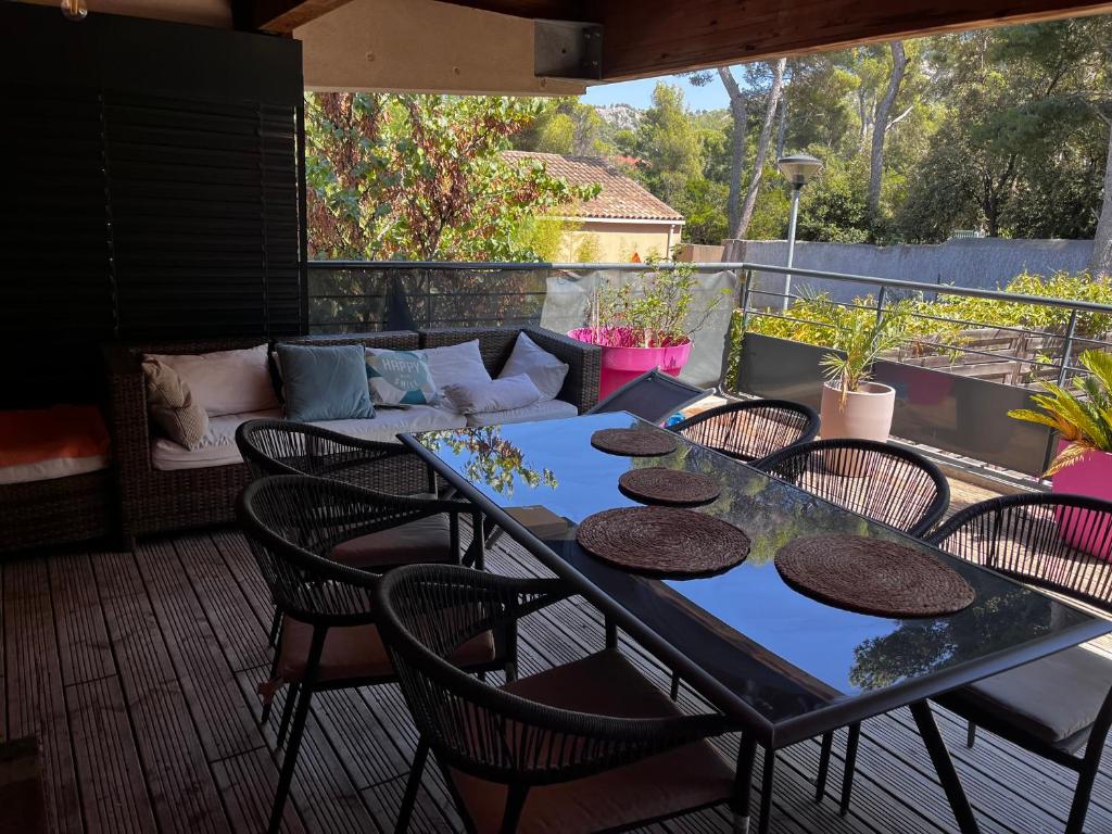 un patio avec une table, des chaises et un canapé dans l'établissement Morgiou Sormiou Marseille T4 climatisé familial - 3 Chambres - Terrasse bois - jardin privatif - Calanques à pied - Plages & Vélodrome à 10 min - Idéal Familles & Randonneurs & Grimpeurs - Escalade à 5 min - Marseille Sud, à Marseille