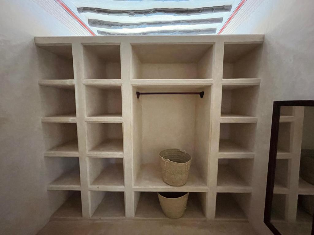 a white book shelf in a room with a skylight at Umma House in Lamu