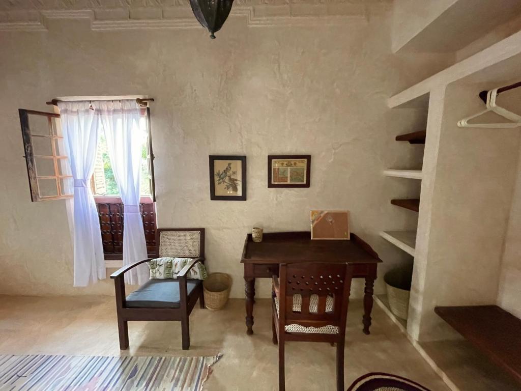 a room with a table and chairs and a window at Umma House in Lamu