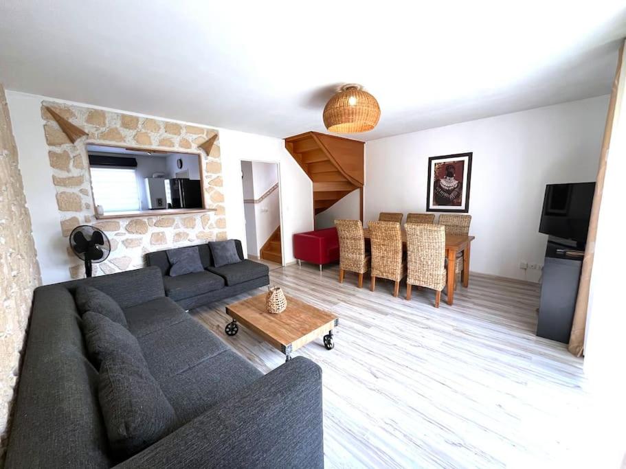 ein Wohnzimmer mit Sofa und Tisch in der Unterkunft Maison cosy à Vaires sur Marne in Vaires-sur-Marne