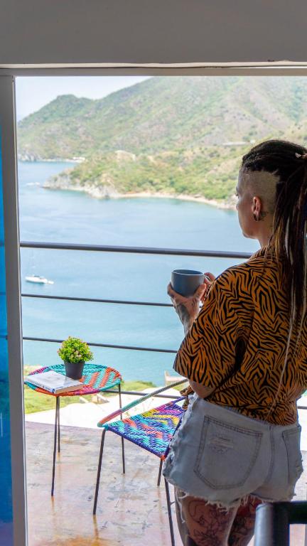 a woman looking out of a window at the water at CASA LOMA BEACH LOFT in Taganga
