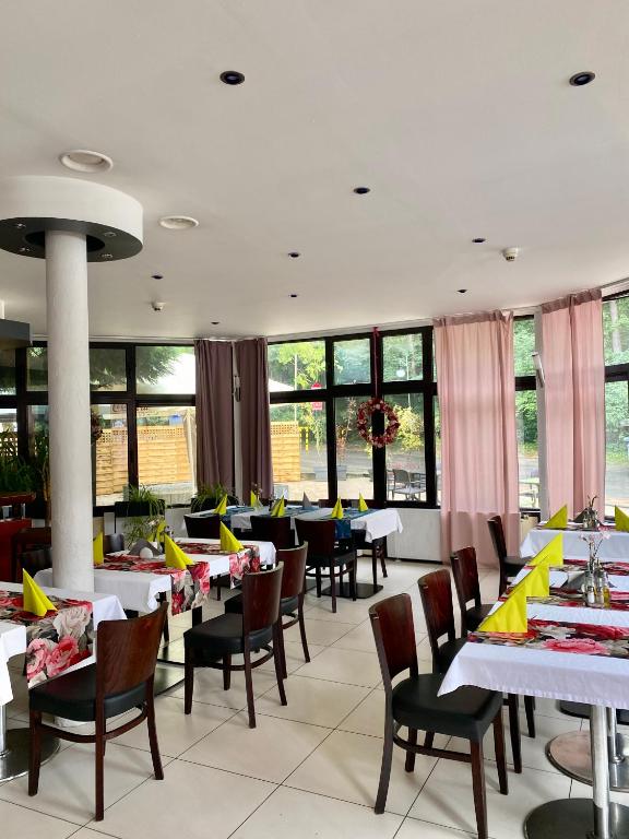 jadalnia ze stołami, krzesłami i oknami w obiekcie Hotel Echo w mieście Cedzyna