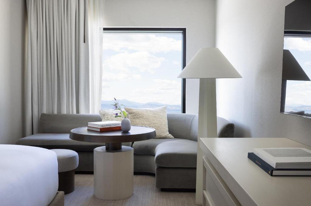 a living room with a couch and a table at Kimpton Claret Hotel by IHG in Denver