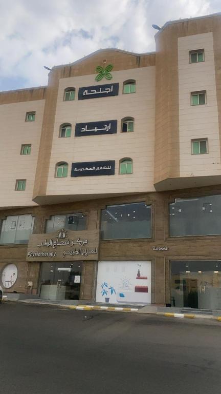 a large building with a clock on the side of it at اجنحة ارتياد للشقق المخدومه in Abha