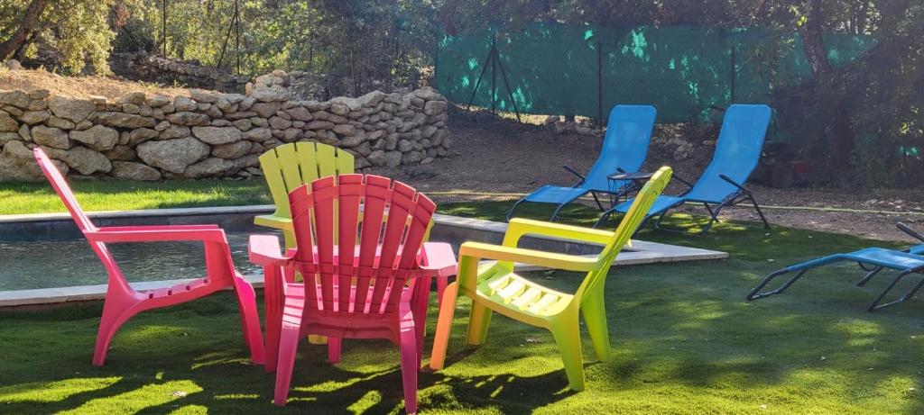 eine Gruppe bunter Stühle im Gras in der Unterkunft Mazet in Rognes