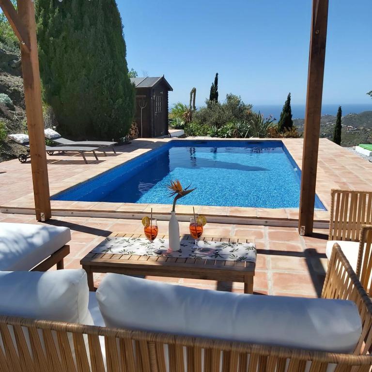 a patio with a table and a swimming pool at Casa los Limones Torrox in Torrox