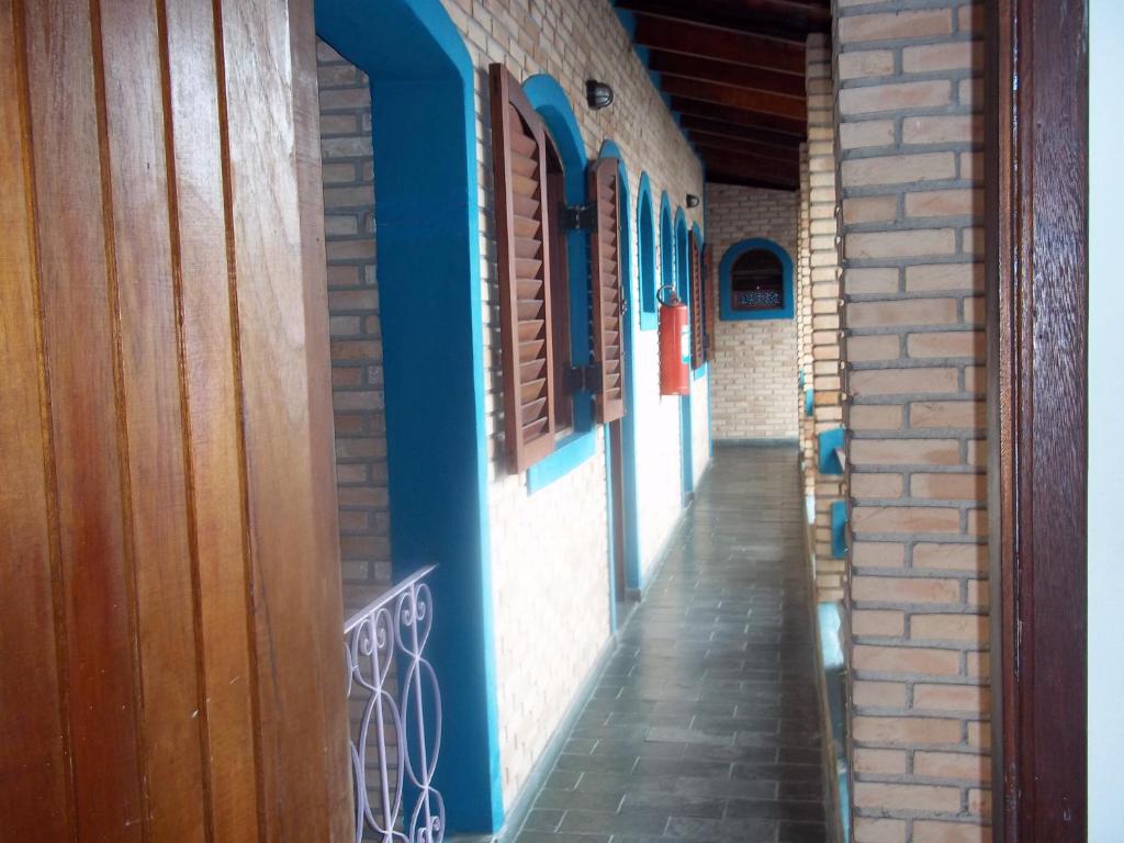 an alley with blue walls and windows on a building at Pousada Riacho Doce in Caraguatatuba