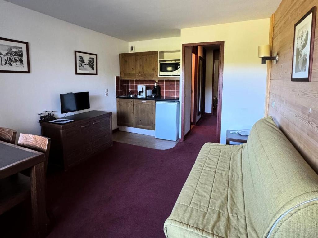 un salon avec un canapé et une cuisine dans l'établissement Résidence Quartz - 2 Pièces pour 4 Personnes 25, à Mâcot La Plagne